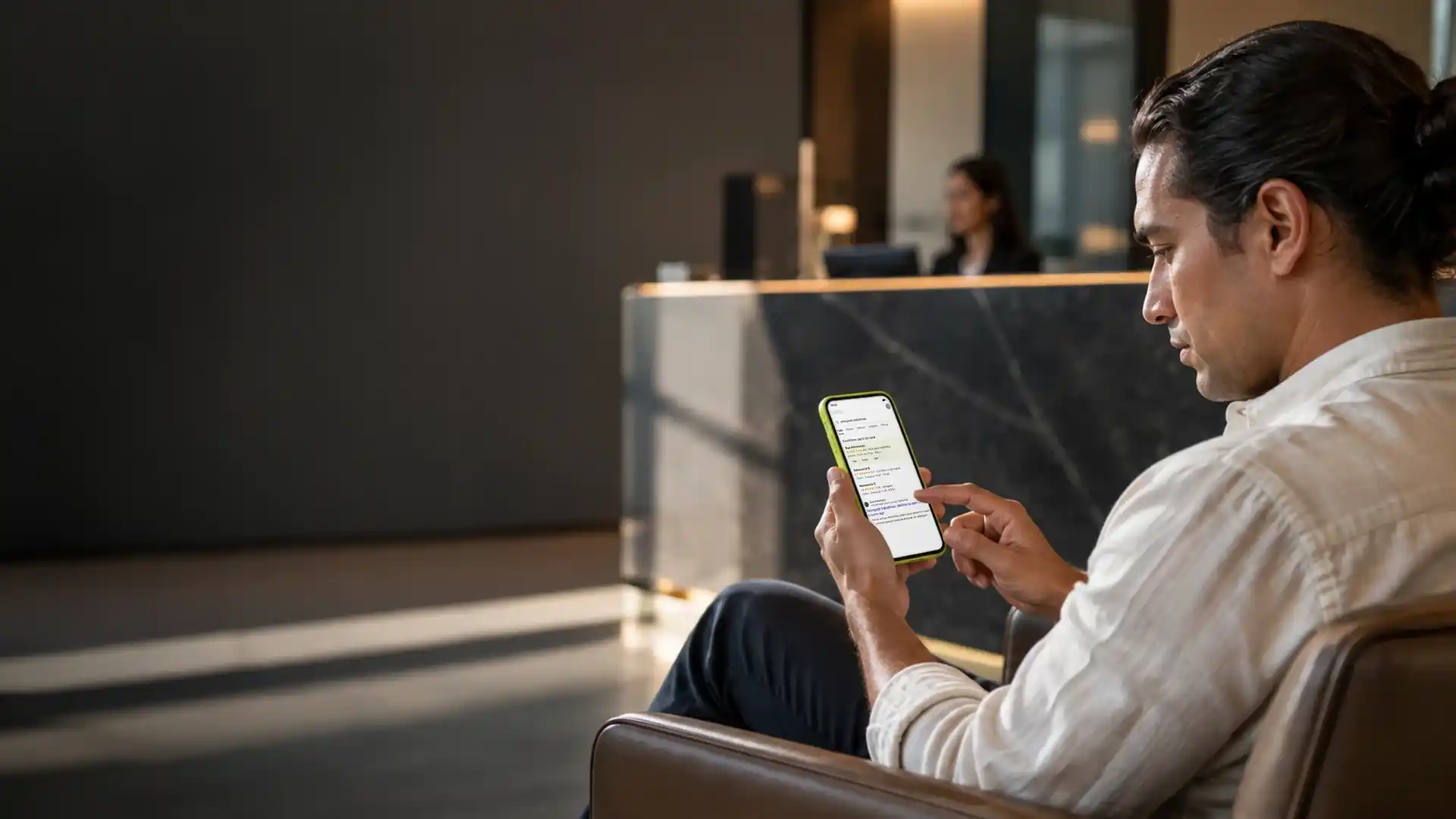 Cliente sentado na recepção de um escritório de advocacia pesquisando no celular